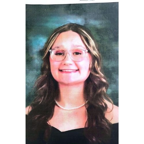 Smiling young woman with glasses and pearls