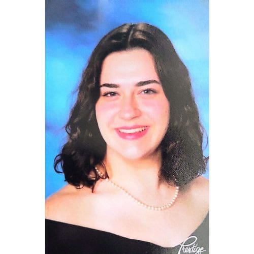 Smiling woman wearing pearl necklace and black drape