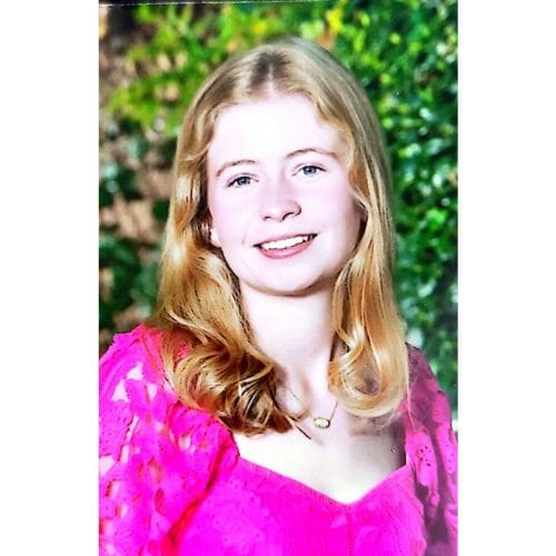 Smiling blonde person wearing pink dress