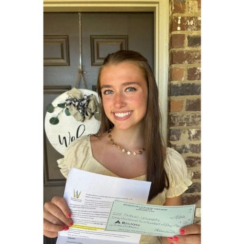 Smiling young woman holding a check and documents