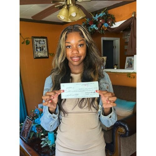 Smiling young woman holding a check